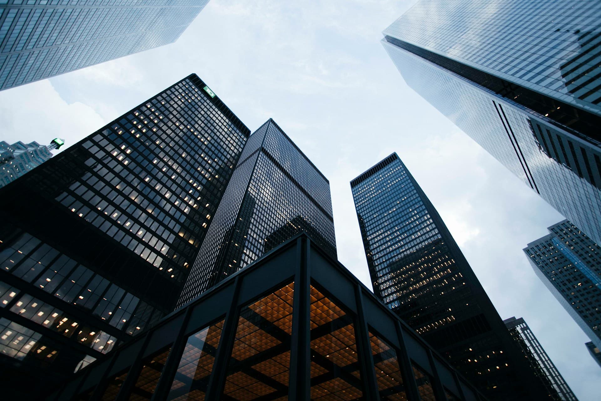Modern luxury building with warmly lit glass facade at dusk